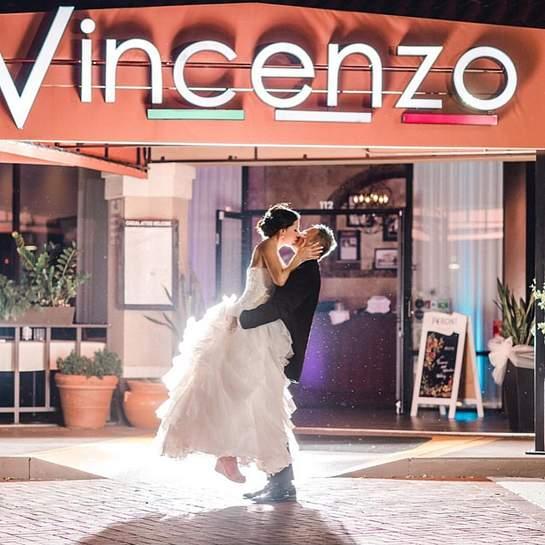 Wedding couple kissing under Vincenzo sign